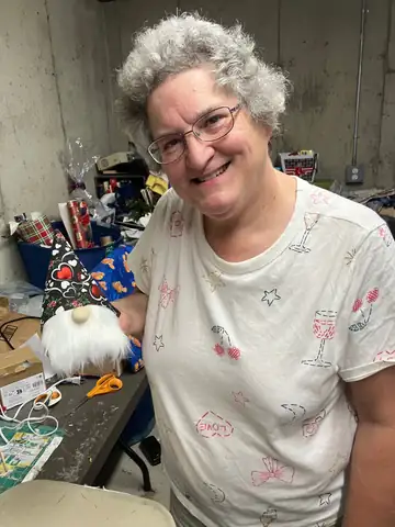 Cathy Pings, The Gnome Lady, holding one of her handmade gnomes.